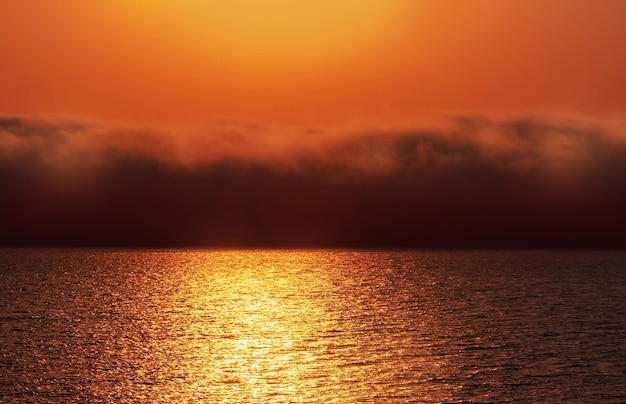 Beau coucher de soleil rouge nuages sombres et océan atlantique à l'horizon