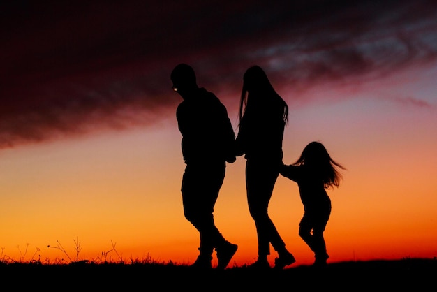 Beau coucher de soleil avec une silhouette familiale