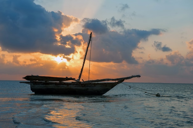 Photo beau coucher de soleil tropical avec bateau dans l'océan