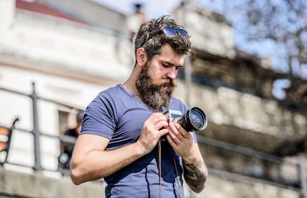 Beau coup équipement photographique rétro homme hipster en lunettes de soleil d'été photo d'un journaliste ou d'un journaliste de la nature Hipster mature avec barbe Homme barbu photographe brutal avec appareil photo