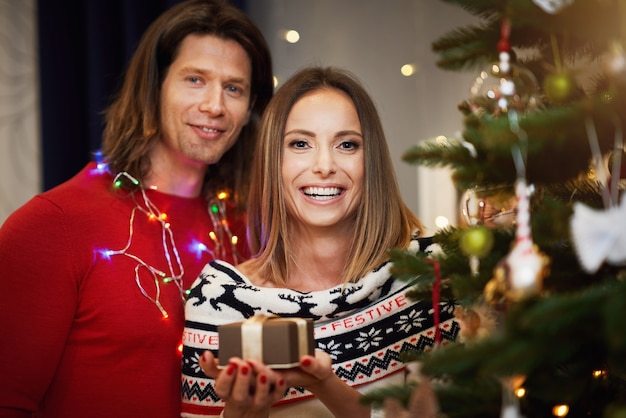 beau couple adulte avec présent sur l'arbre de Noël