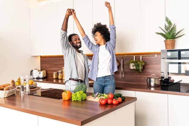 Beau couple afro-américain cuisinant à la maison Beau couple noir préparant le dîner