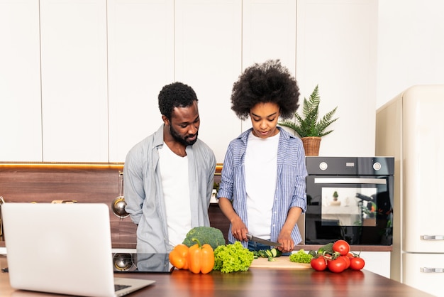 Beau couple afro-américain cuisinant à la maison Beau couple noir préparant le dîner