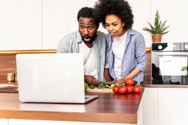 Beau couple afro-américain cuisinant à la maison Beau couple noir préparant le dîner