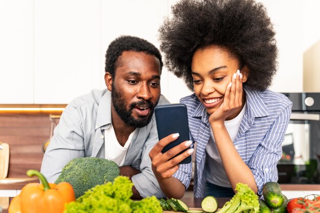 Beau couple afro-américain cuisinant à la maison Beau couple noir préparant le dîner