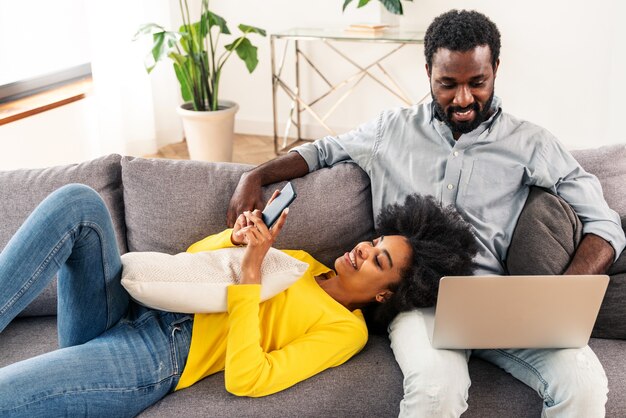 Beau couple afro-américain travaillant sur un ordinateur portable - Couple moderne faisant ses achats en ligne