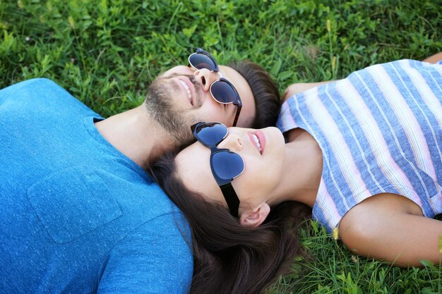 Beau couple allongé sur l'herbe verte