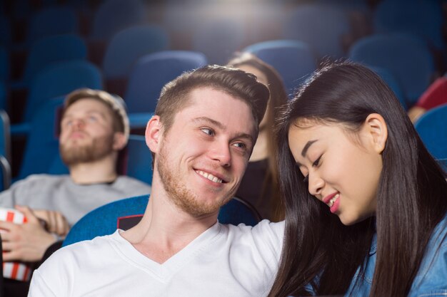 beau couple amoureux au cinéma homme heureux en regardant sa petite amie souriante avec amour
