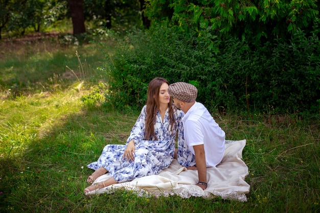 Beau couple amoureux au pique-nique se sourit à la nature verdoyante. date d'été au parc