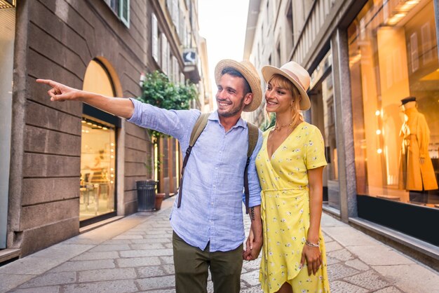 Beau couple d'amoureux faisant du shopping dans le centre-ville. Des touristes ludiques visitant une célèbre ville européenne