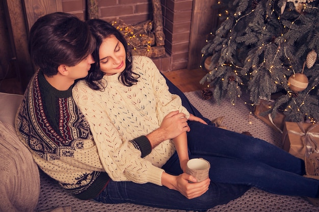 Photo beau couple d'amoureux romantique caucasien brune dans des chandails chauds et confortables dans la cabine
