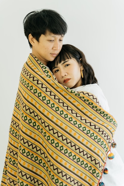 Photo beau couple asiatique enveloppé dans une couverture