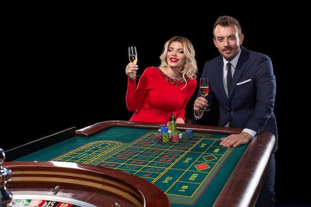 Beau couple bien habillé jouant à la roulette au casino