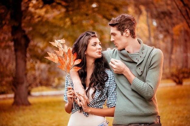 Beau couple charmant marchant et profitant du parc aux couleurs de l'automne.