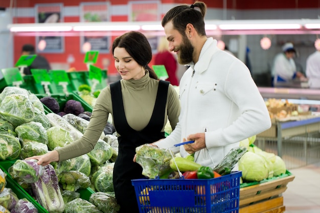 Beau couple choisit le chou dans un supermarché