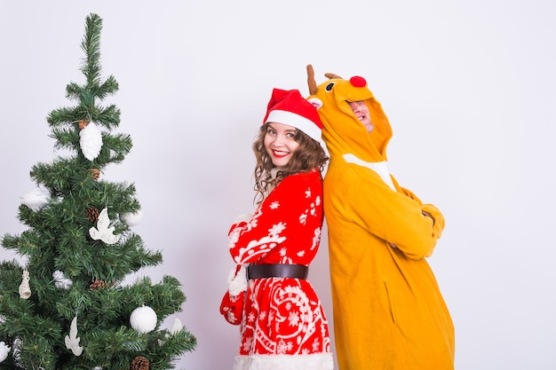 Beau couple en costumes de Noël près de l'arbre de Noël