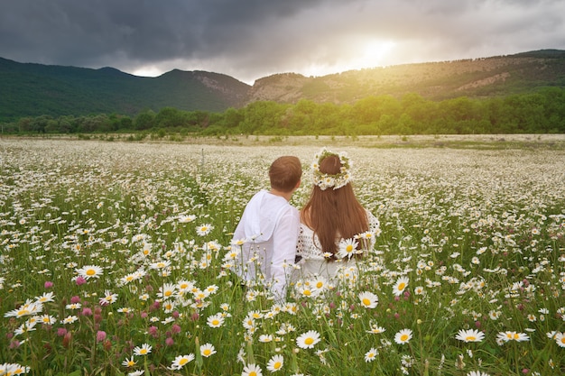 Beau couple dans la prairie de marguerite.