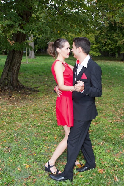 Beau couple dans des vêtements lumineux dansant sur le parc