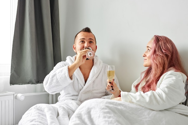 Beau Couple A Du Temps Romantique Sur Le Lit En Buvant Du Champagne