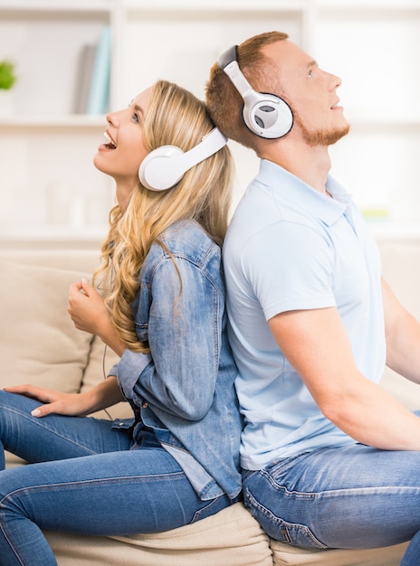 Beau couple écoute de la musique avec des écouteurs.