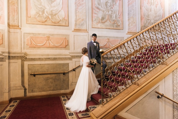 Beau couple élégant de jeunes mariés amoureux dans un intérieur luxueux dans les escaliers