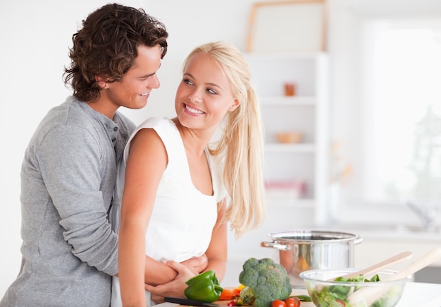 Beau couple étreindre pendant la cuisson