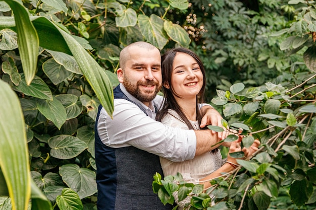 Beau couple fille et mec dans le parc parmi les arbres tropicaux