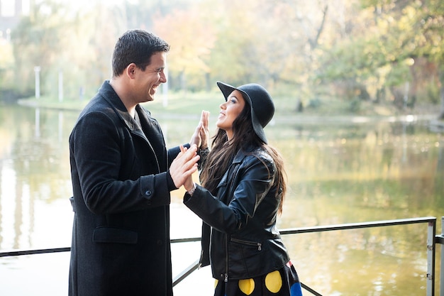 Beau couple gourmand marchant dans un parc d'automne près d'un lac