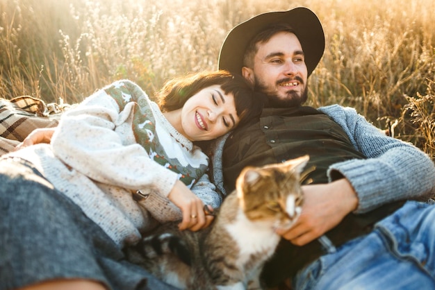 Beau couple hipster avec chat Couple portant de beaux chapeaux et chandails