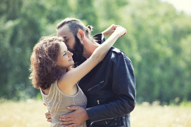 Beau couple homme et femme amoureuse sur le terrain contre le ciel heureux