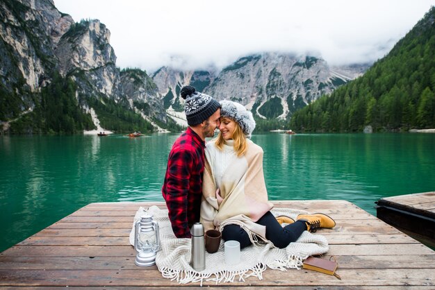 Beau couple de jeunes adultes visitant un lac alpin à Braies Italie