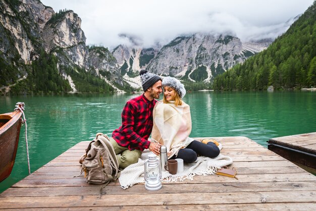 Beau couple de jeunes adultes visitant un lac alpin à Braies Italie