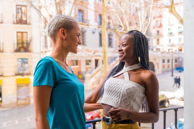 Beau couple de lesbiennes parlant et s'amusant sur le balcon à la maison concept lgbt