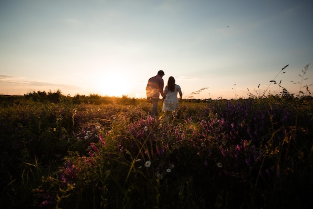 Beau couple marchant dans le champ d'été