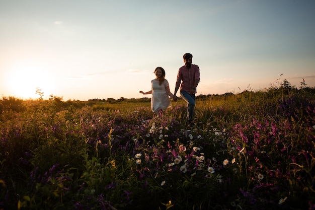 Beau couple marchant dans le champ d'été