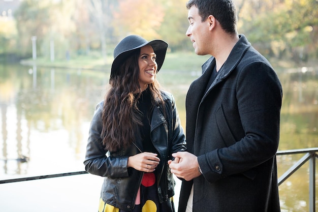 Beau couple marchant dans le parc d'automne près d'un lac