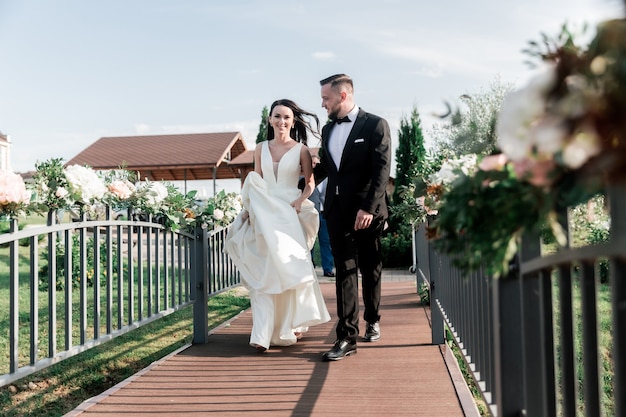 Beau couple marchant sur le pont dans le parc. vacances et événements