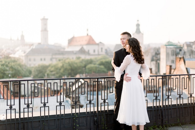 Beau couple de mariage chinois embrassant et regardant le lever du soleil