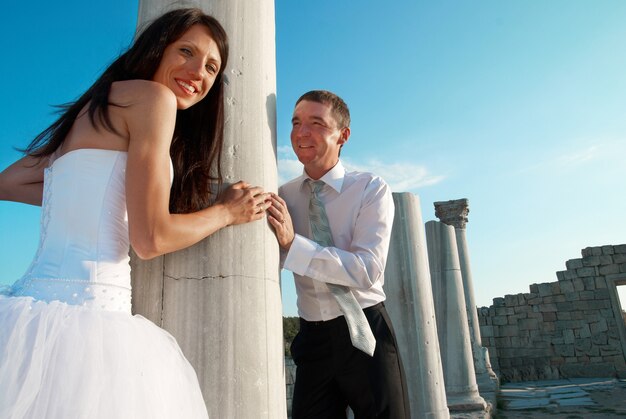 Beau couple de mariage mariée et le marié près de la colonne de la Grèce dans la ville antique