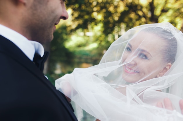 Photo beau couple de mariage posant dans la forêt