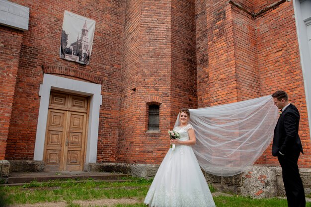 Beau couple de mariage posant près du mur