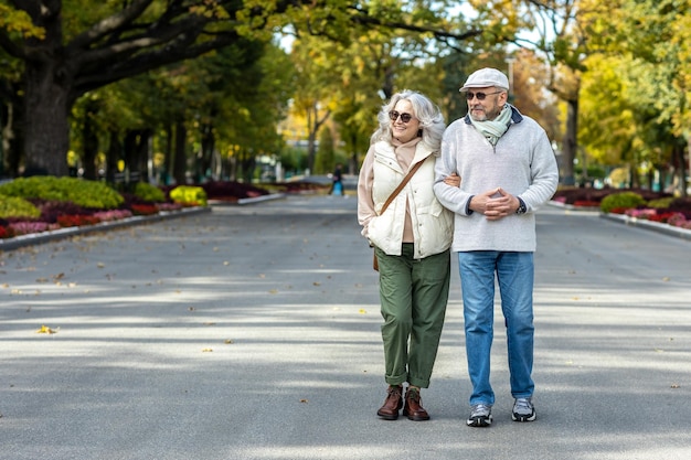 Un beau couple marié sur une promenade dans un parc d'automne