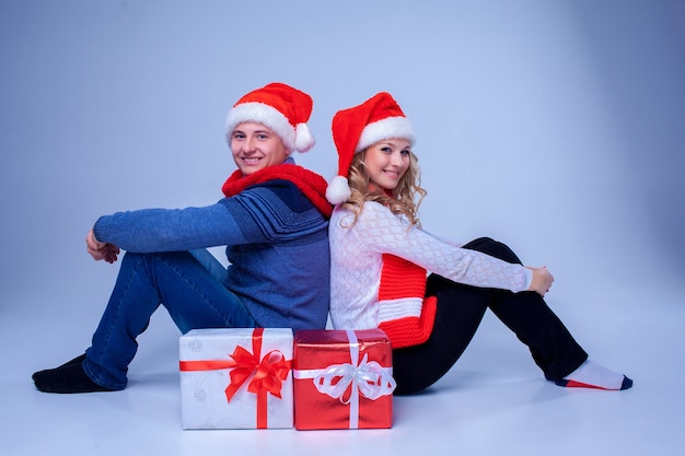 Beau couple de noël assis avec des cadeaux