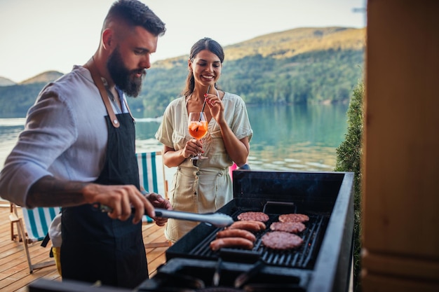 Beau couple passant ensemble une journée de barbecue et buvant des cocktails