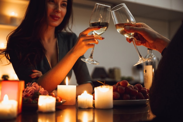 Beau couple passionné ayant un dîner romantique aux chandelles à la maison, boire du vin, griller