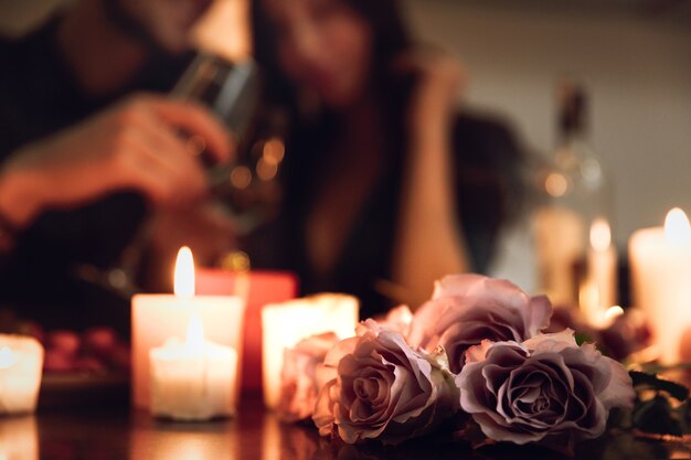 Beau couple passionné ayant un dîner romantique aux chandelles à la maison, boire du vin, griller