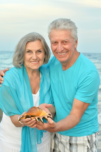 Beau couple de personnes âgées heureux reste au tropical resort avec shell