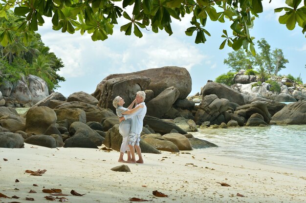 Un beau couple de personnes âgées heureux se repose dans un complexe tropical