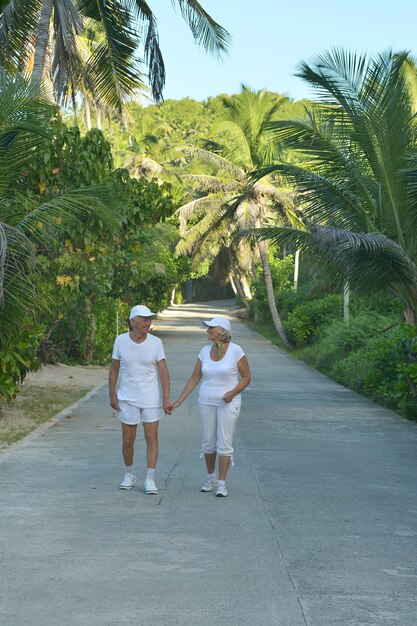 Un beau couple de personnes âgées heureux se repose dans un complexe tropical