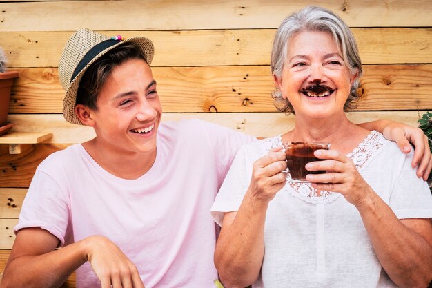 Beau couple de personnes s'amusant et plaisantant avec une grand-mère buvant du chocolat chaud